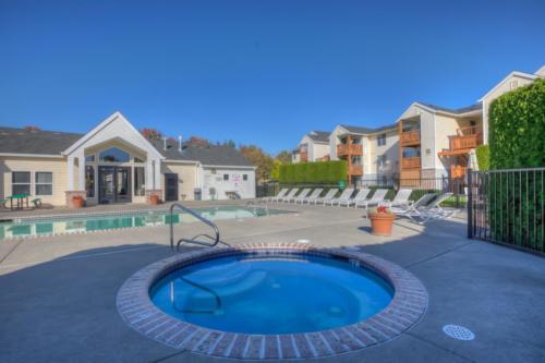 hot tub and pool with apartments behind